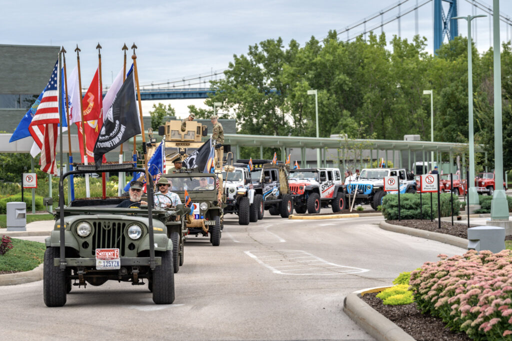 Line of cars with a variety of flags on the first car