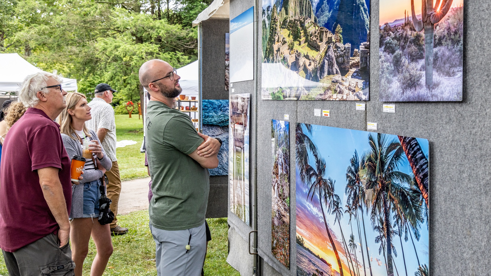 people looking at paintings at the crosby festival of the arts
