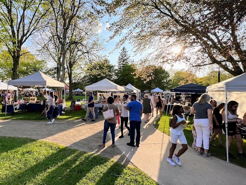 people walking around the toledo night market at the Toledo Botanical gardens
