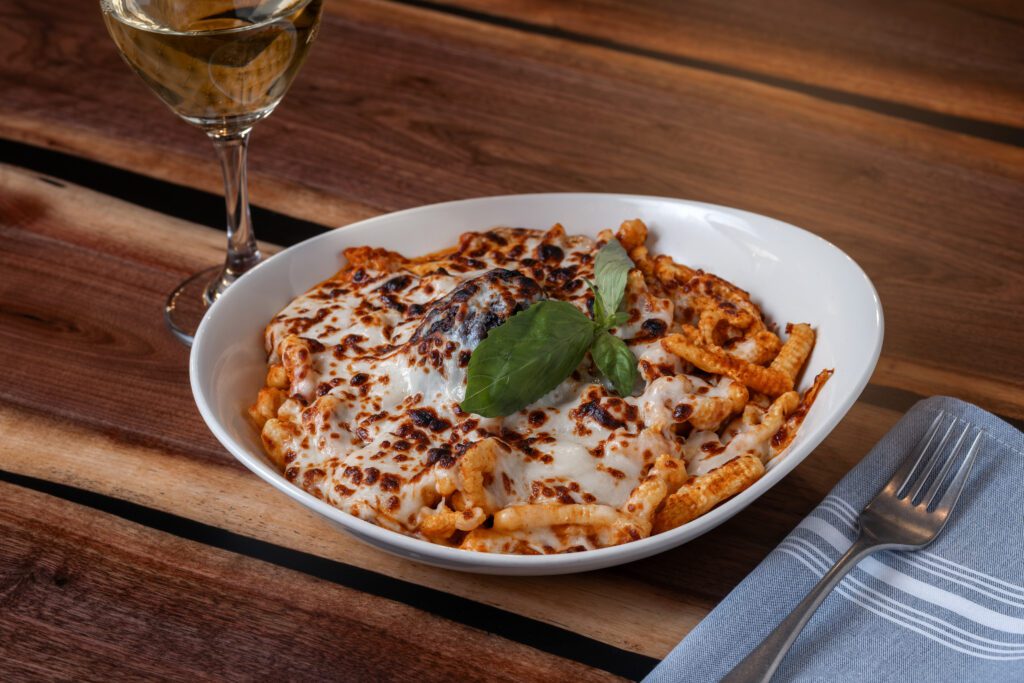 Pasta dish with toasted cheese on top at Regalo