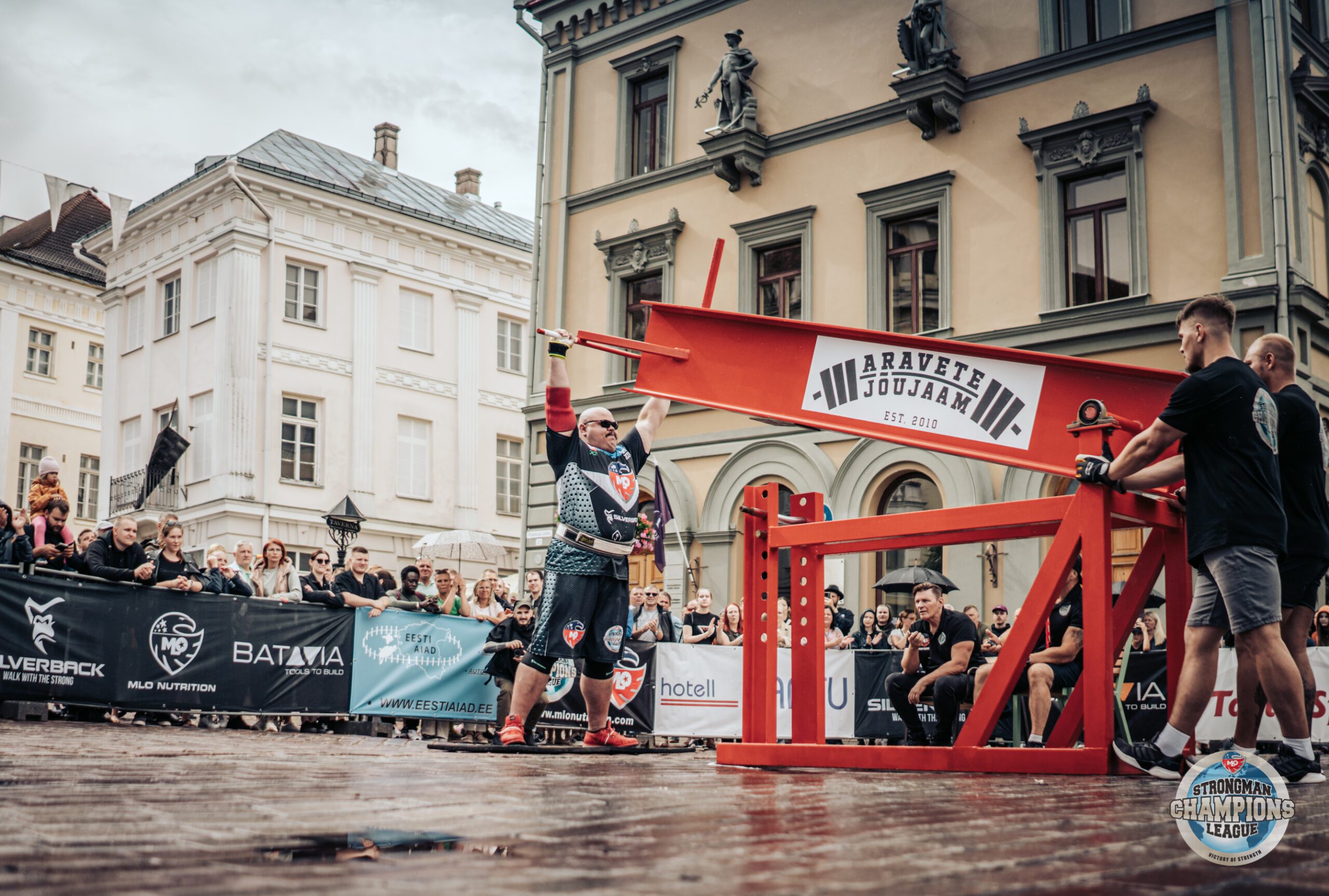 Strongman lifts a heavy steel beam during the competition.